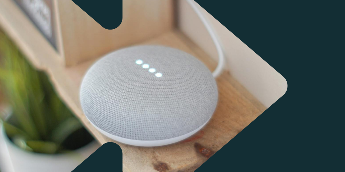 A Google Home device sitting on a shelf with four lights lit up